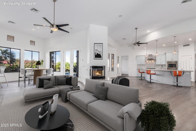 living room with a towering ceiling and light hardwood / wood-style floors