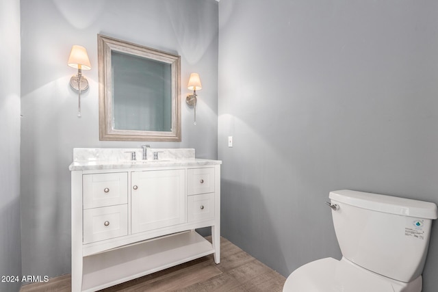 bathroom with hardwood / wood-style floors, vanity, and toilet