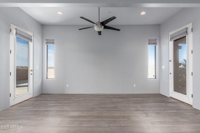 spare room with light wood-type flooring and ceiling fan