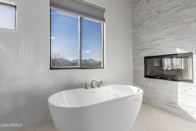 bathroom with a tub to relax in, tile patterned flooring, and a multi sided fireplace