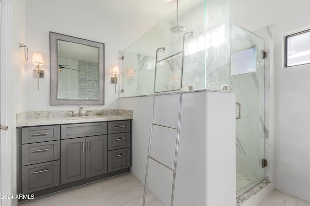 bathroom with ceiling fan, tile patterned flooring, vanity, and a shower with shower door