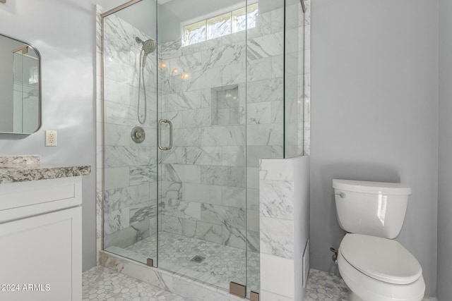 bathroom with tile patterned flooring, vanity, toilet, and a shower with shower door