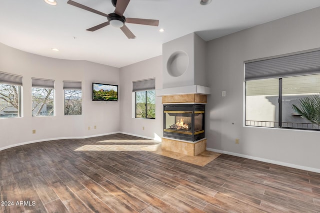 unfurnished living room with ceiling fan and a multi sided fireplace