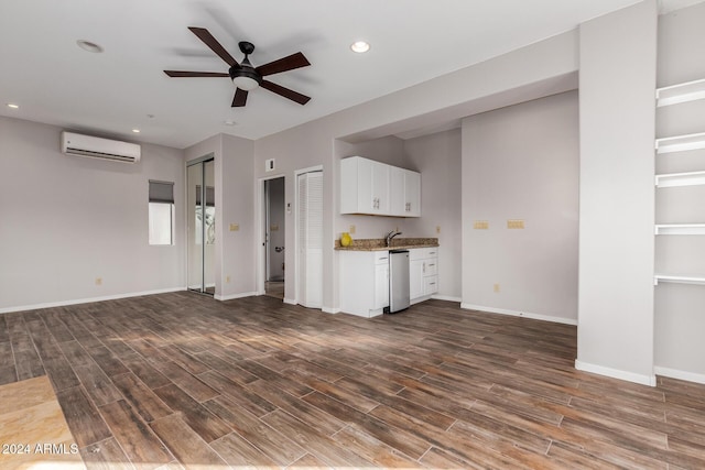 unfurnished living room featuring an AC wall unit, ceiling fan, and sink