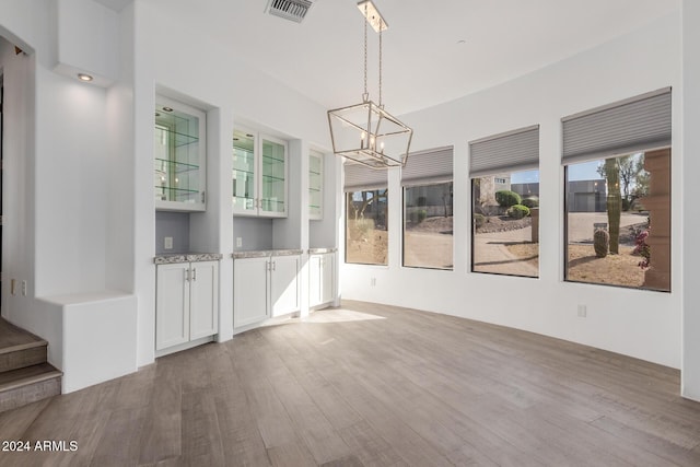 interior space featuring light hardwood / wood-style floors, a healthy amount of sunlight, and a notable chandelier