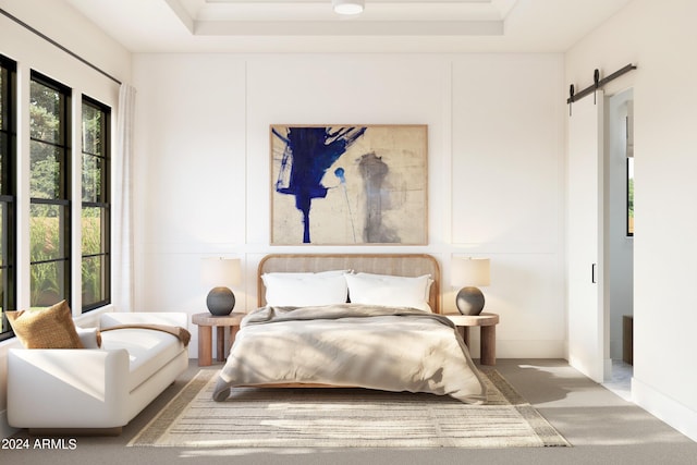 bedroom featuring a raised ceiling, a barn door, carpet flooring, and multiple windows