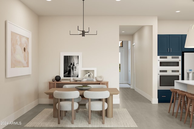 dining area featuring light hardwood / wood-style flooring and a chandelier