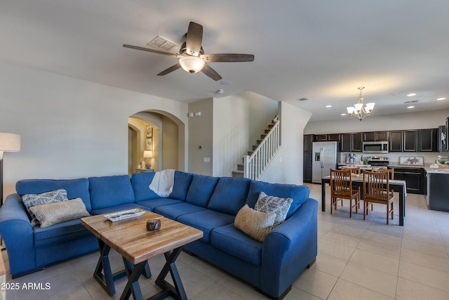 living room featuring ceiling fan with notable chandelier and light tile patterned flooring