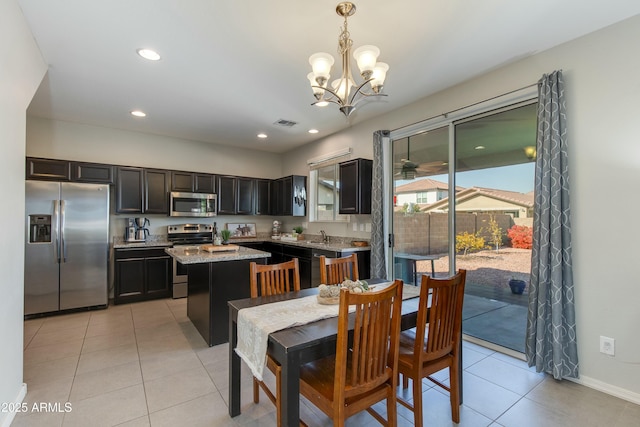 tiled dining room featuring a chandelier