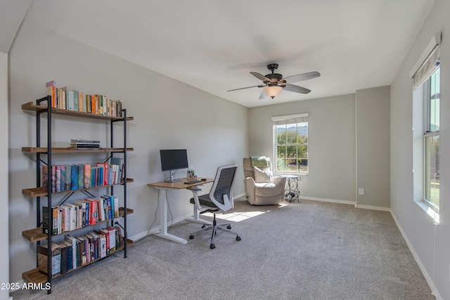 carpeted office space featuring ceiling fan