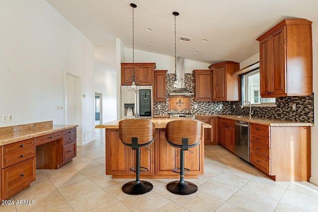 kitchen featuring wall chimney exhaust hood, lofted ceiling, hanging light fixtures, a kitchen island, and stainless steel appliances