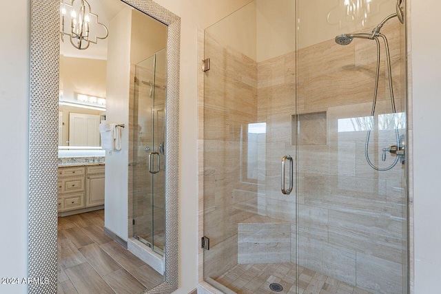 bathroom featuring vanity, a shower with door, and a notable chandelier