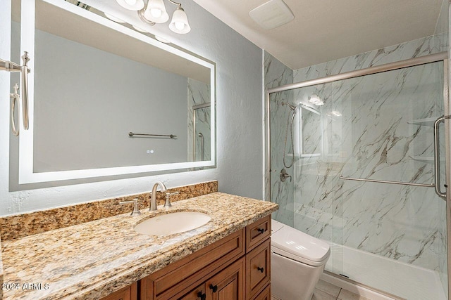 bathroom featuring vanity, an enclosed shower, and toilet