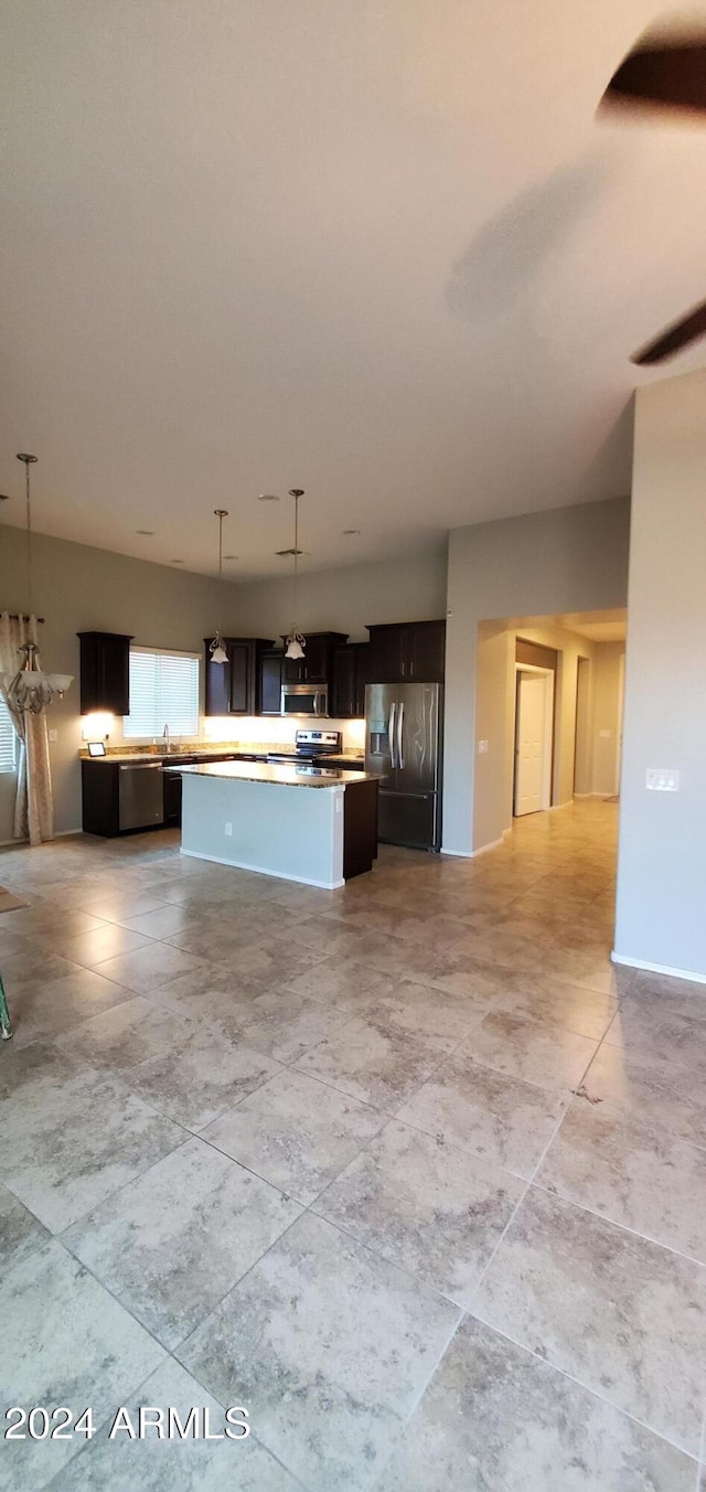 kitchen with hanging light fixtures, stainless steel fridge, and a kitchen island