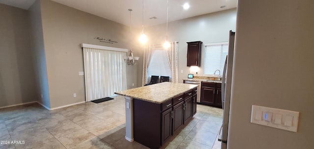 kitchen with sink, dishwasher, dark brown cabinets, a center island, and decorative light fixtures