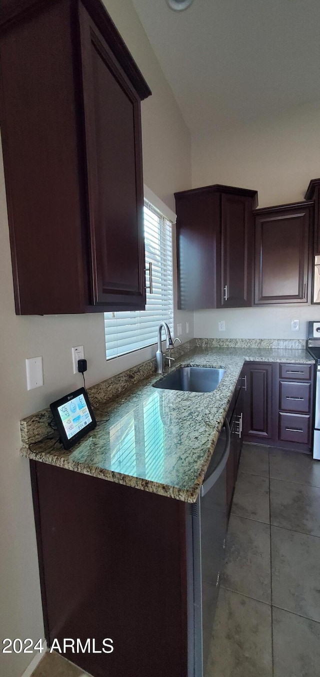 kitchen with dark brown cabinetry, appliances with stainless steel finishes, sink, and light stone counters