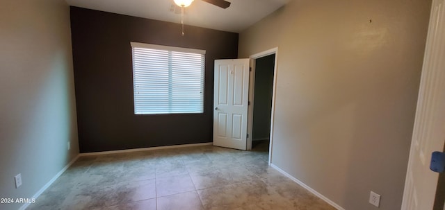 tiled spare room featuring ceiling fan