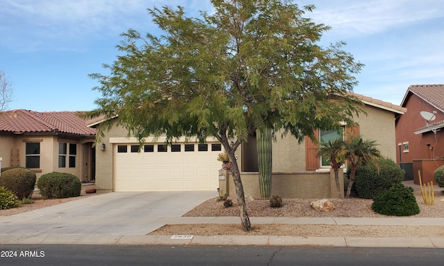 obstructed view of property featuring a garage and central AC