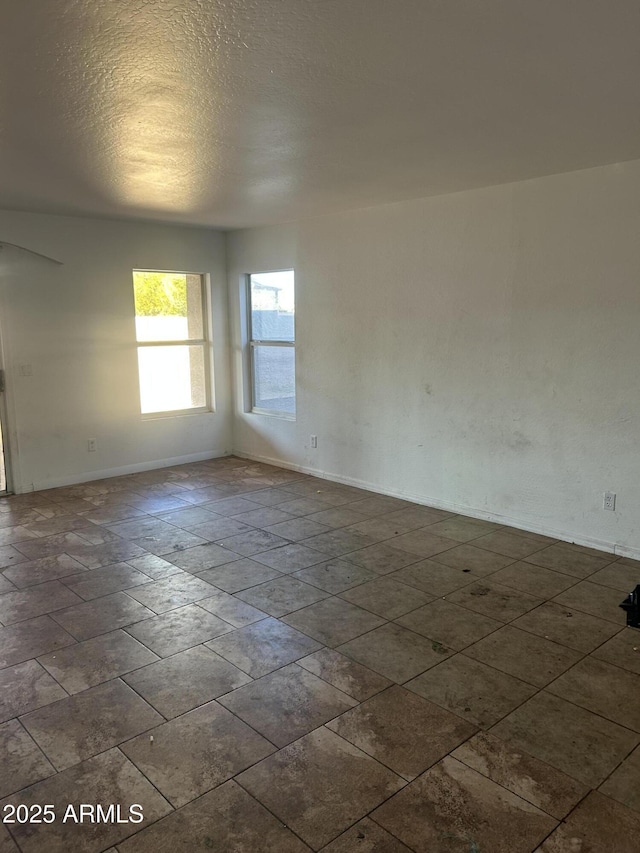 spare room with baseboards