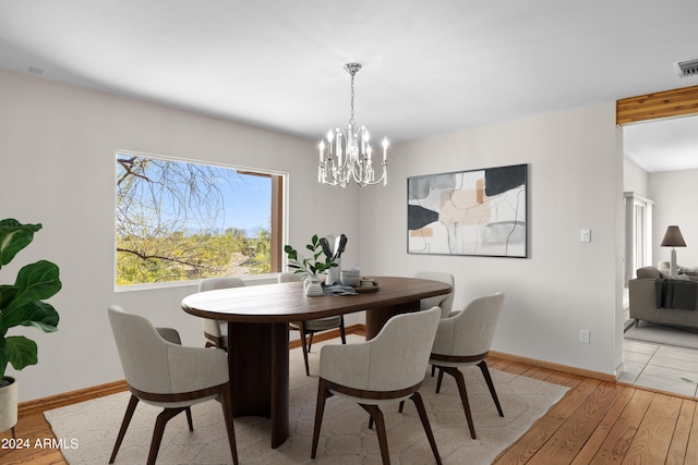 dining space featuring light hardwood / wood-style flooring and a chandelier