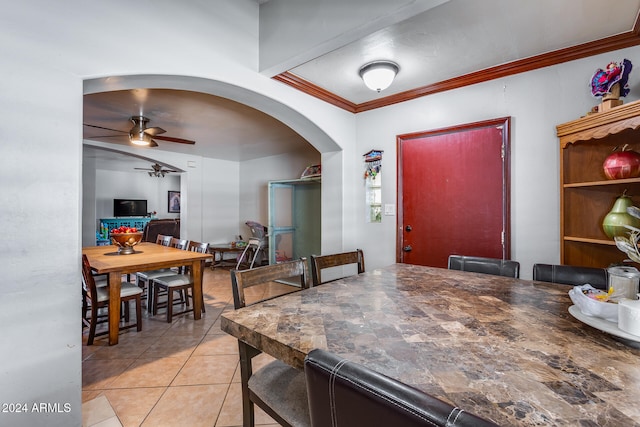 tiled dining area with ornamental molding and ceiling fan