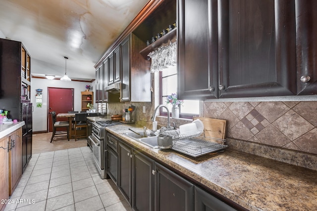 kitchen featuring dark brown cabinetry, decorative light fixtures, backsplash, stainless steel range oven, and vaulted ceiling