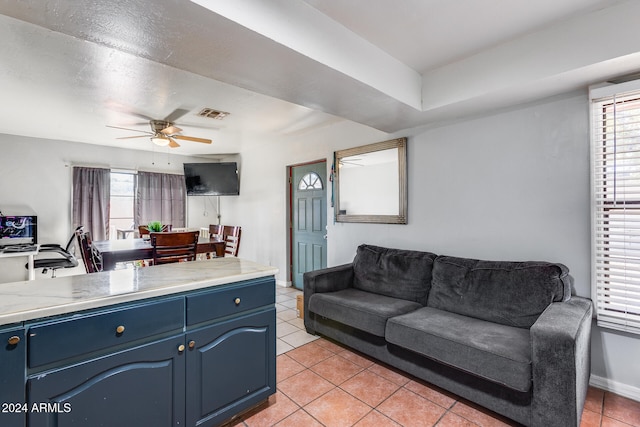 tiled living room featuring ceiling fan