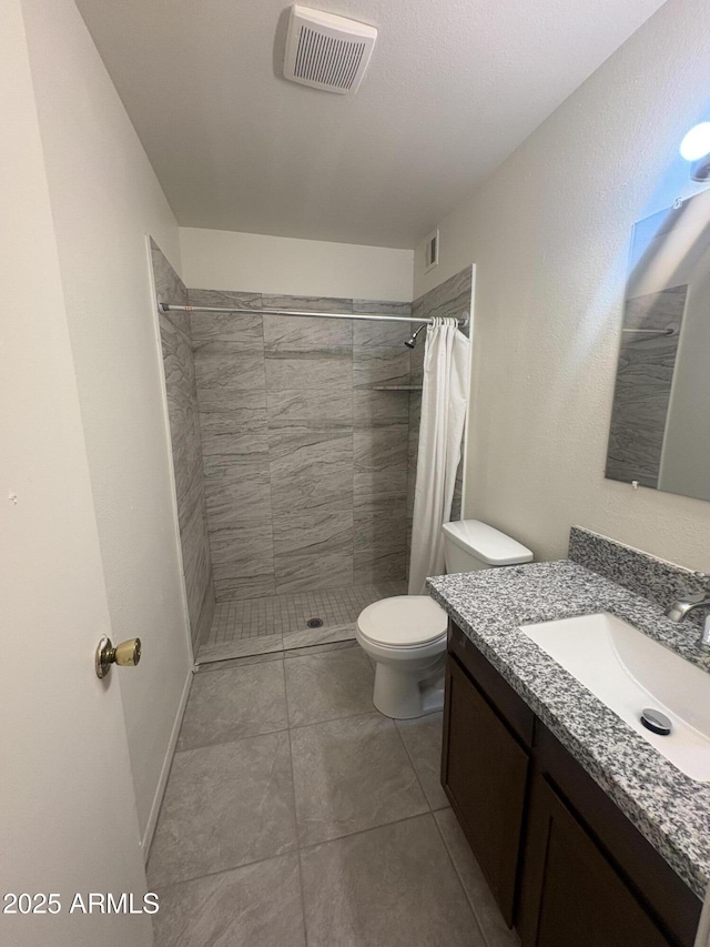 6605 N 46th Ln, Glendale, AZ 85301 - full bath featuring toilet, a tile shower, vanity, and tile patterned flooring