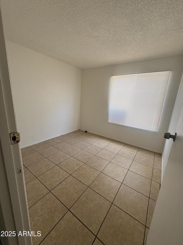 6605 N 46th Ln, Glendale, AZ 85301 - spare room featuring light tile patterned floors and a textured ceiling