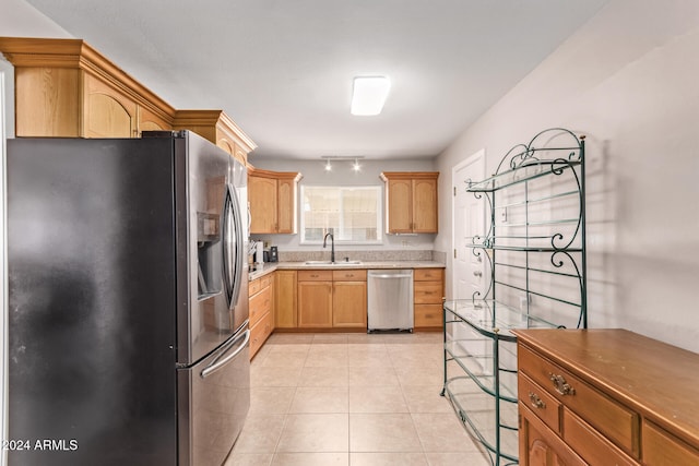 kitchen featuring light brown cabinetry, sink, light tile patterned flooring, and stainless steel appliances