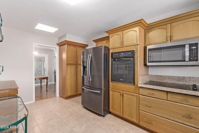 kitchen featuring light stone countertops, black appliances, and light tile patterned floors