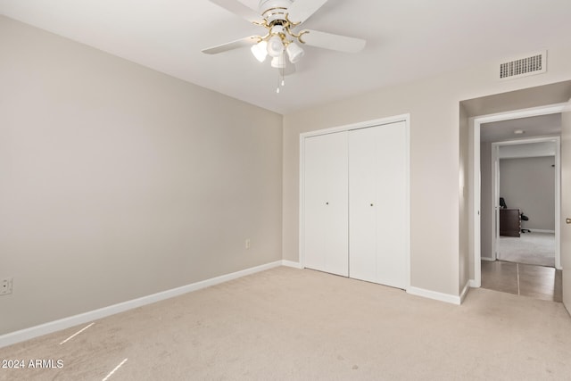 unfurnished bedroom featuring light colored carpet, a closet, and ceiling fan