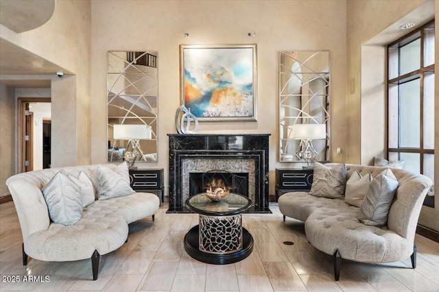 sitting room with hardwood / wood-style floors and a premium fireplace