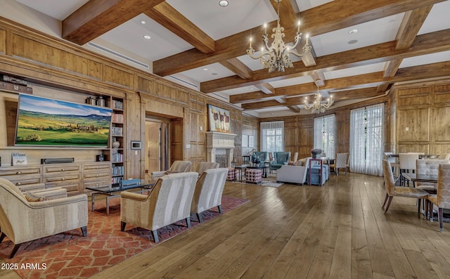 living room featuring beam ceiling, wooden walls, coffered ceiling, a notable chandelier, and wood-type flooring