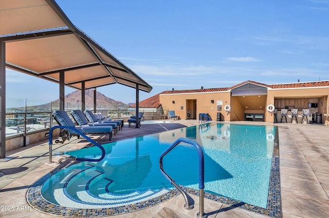 view of pool with a mountain view, an outdoor bar, and a patio area