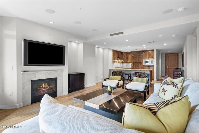 living room with light wood-type flooring and a fireplace