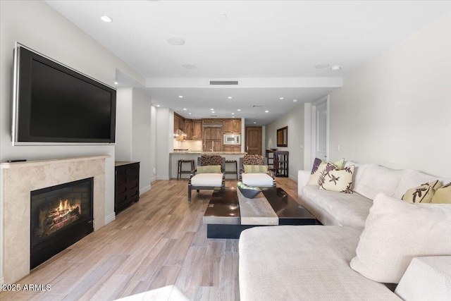 living room with a fireplace and light hardwood / wood-style flooring