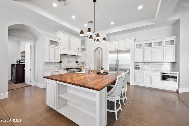 10448 E Glencove St, Mesa, AZ 85207 - kitchen with open shelves, arched walkways, wood counters, built in fridge, and visible vents