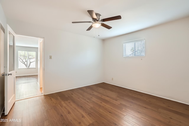 empty room with dark wood-style flooring and a ceiling fan