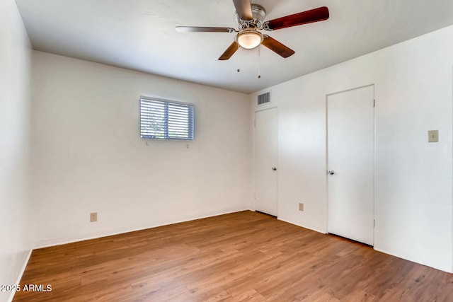 unfurnished room with visible vents, ceiling fan, and light wood-type flooring