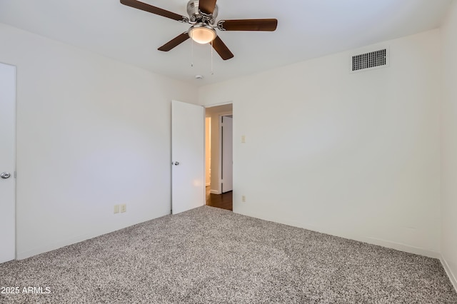 empty room with carpet, visible vents, and a ceiling fan