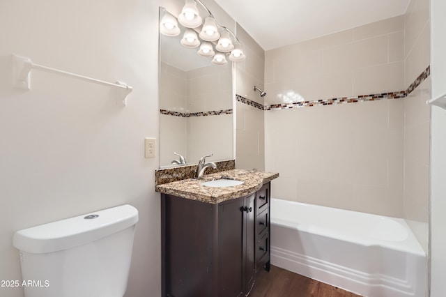bathroom with wood finished floors, shower / washtub combination, toilet, and vanity