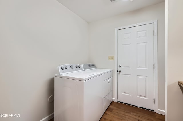 laundry area featuring washing machine and clothes dryer, wood finished floors, and laundry area