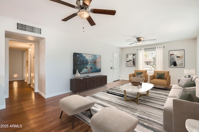 living room with wood finished floors, visible vents, ceiling fan, and baseboards