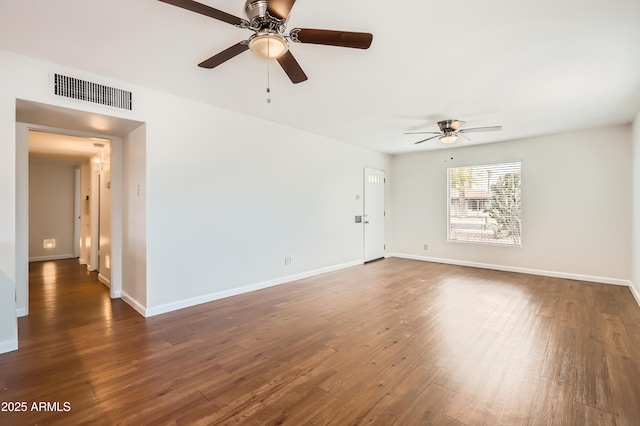 unfurnished room featuring dark wood-style flooring, visible vents, ceiling fan, and baseboards