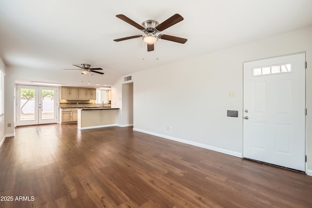 unfurnished living room with a ceiling fan, visible vents, baseboards, and dark wood finished floors