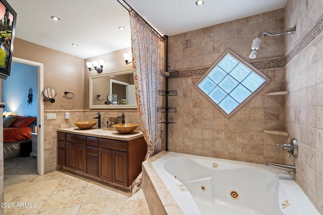 bathroom featuring tile patterned floors, vanity, tiled bath, and tile walls