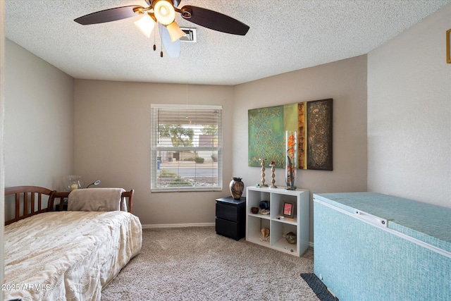 bedroom featuring light carpet, ceiling fan, and a textured ceiling