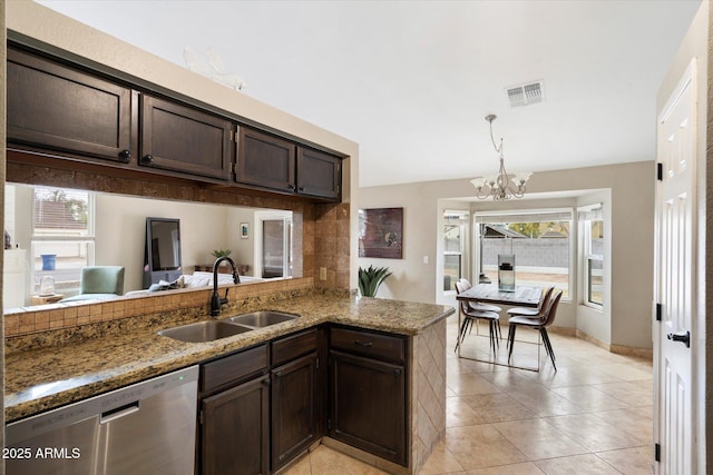 kitchen featuring dark brown cabinetry, sink, stainless steel dishwasher, and kitchen peninsula