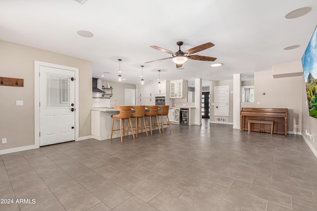 tiled living room featuring ceiling fan and sink